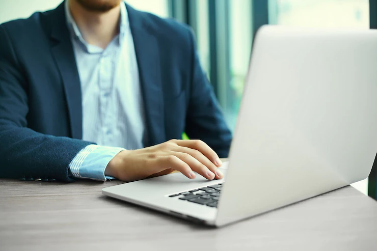 young-man-working-with-laptop-man-s-hands-notebook-computer-business-person-workplace_158538-8138